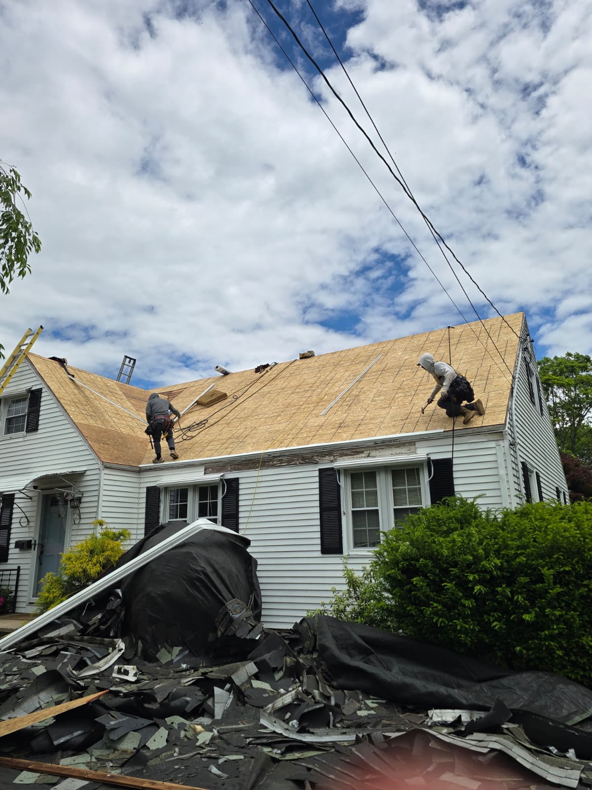 Crew installing new roof decking on cape cod home